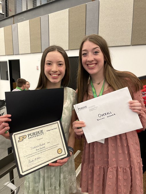 Two girls pose with Science fair Certificates