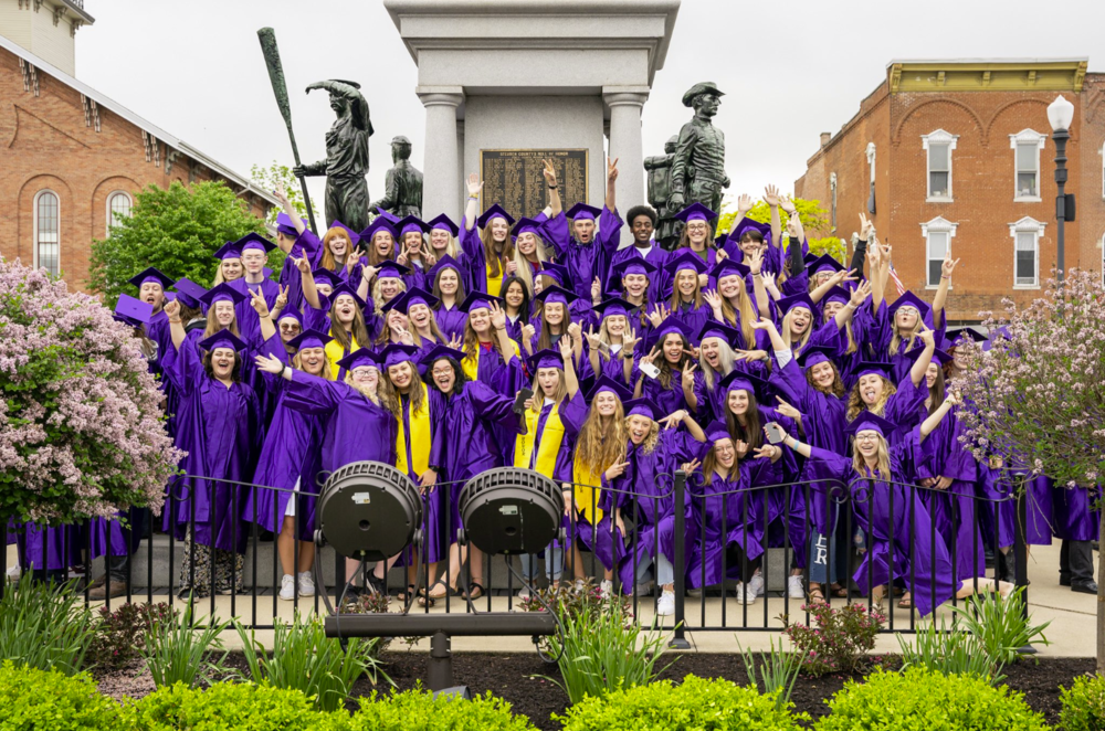 Seniors in their purple caps and gowns, gathered around the Soldier's Monument in Angola, Indiana