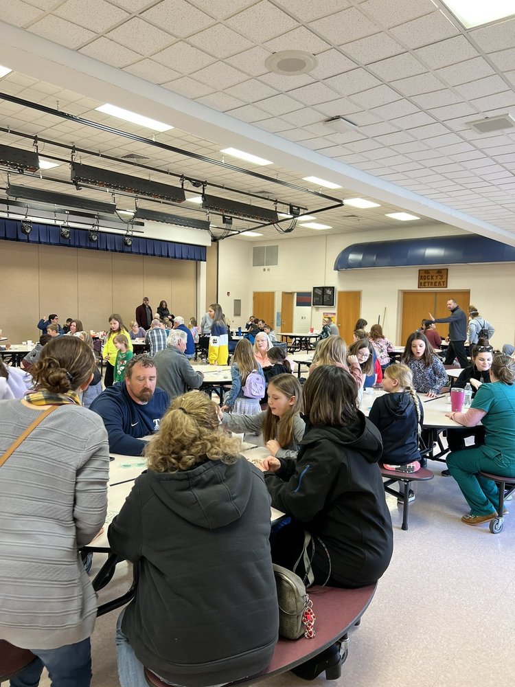 Families gathered at round tables in the cafeteria for bingo