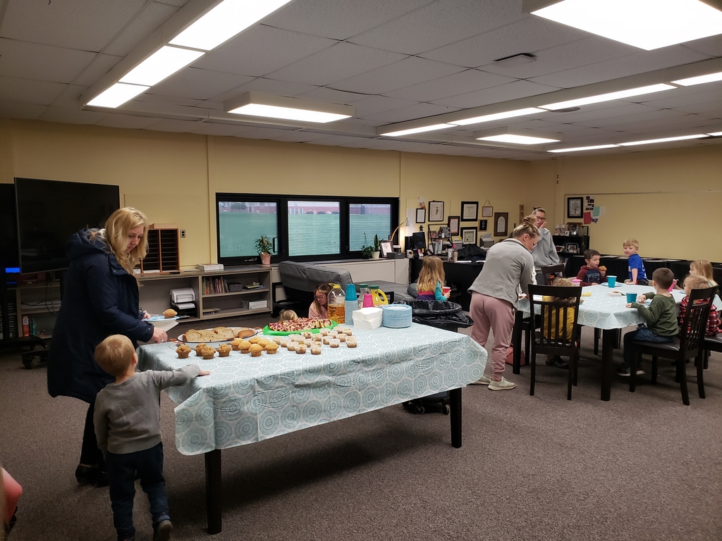 Students, moms, and staff members eating breakfast 