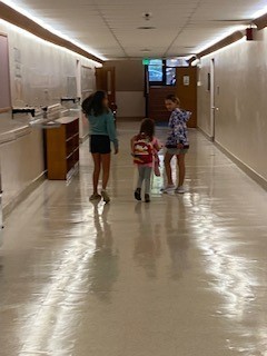 3 students walking down the hallway 