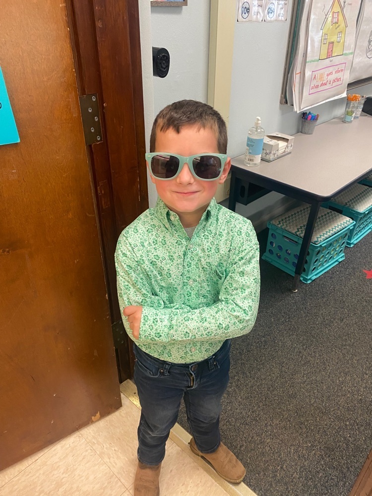 young boy with a green shirt and green sunglasses 
