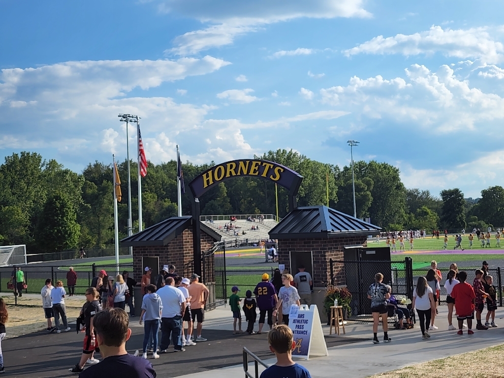 Two ticket booths at the entrance to the stadium, with an arch between that reads "Hornets"
