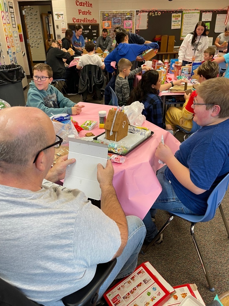 students and families making gingerbread houses  