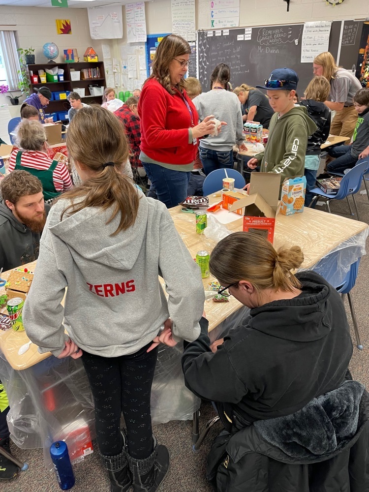 students and families making gingerbread houses